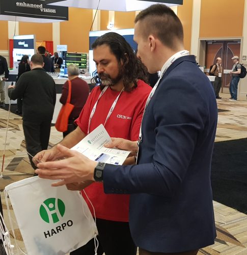 Employee of Harpo explaining SUITCEYES to a vistor of CSUN AT Conference